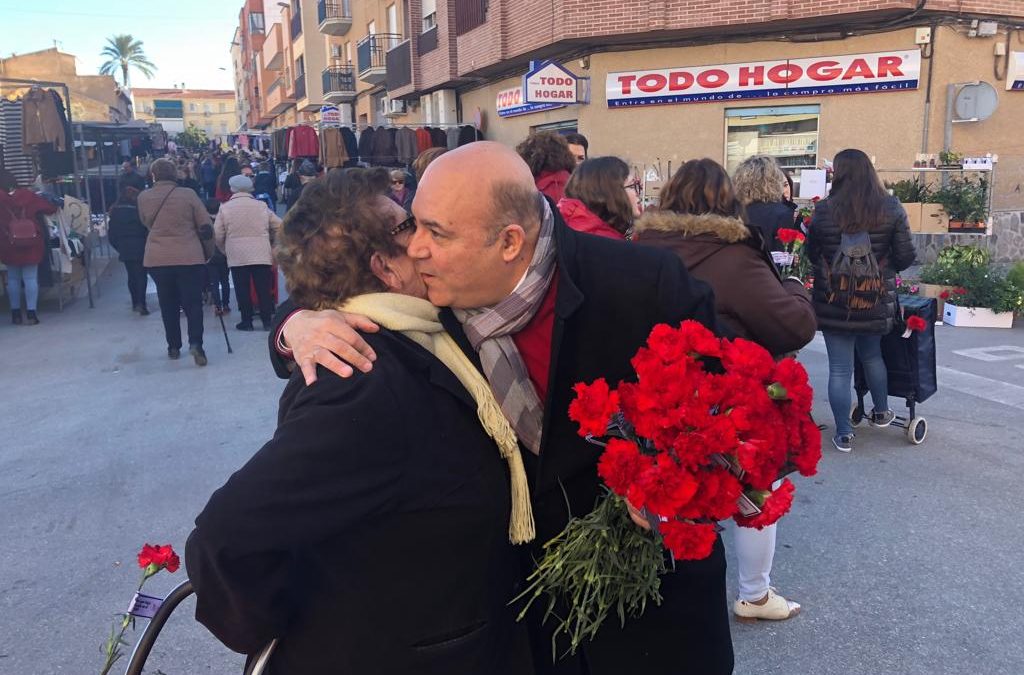 Pascual Lucas junto al grupo municipal socialista felicita el año con un reparto de claveles en el mercado semanal